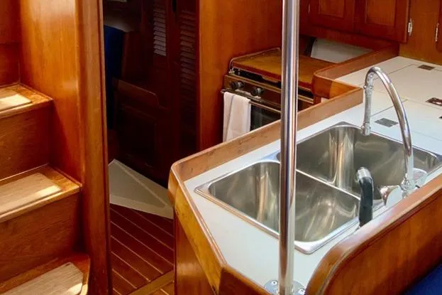 Slide: The Image of Interior of a 1995 Freedom 35 sailboat featuring a wooden kitchen with a double sink. - 13