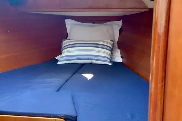 Slide: The Image of Cozy cabin bed in a 1995 Freedom 35 sailboat with striped pillows. - 14