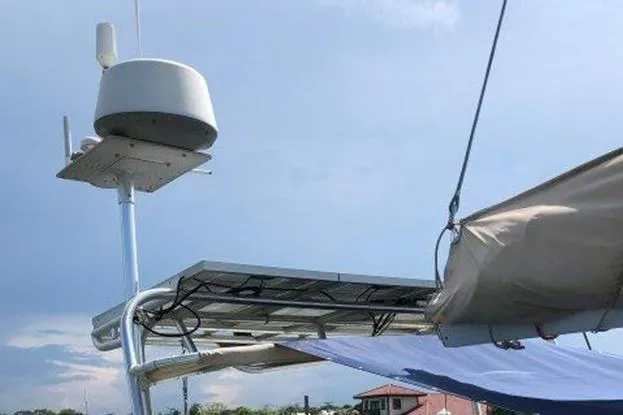Slide: The Image of Radar and solar panel setup on a 1995 Freedom 35 sailboat under a clear sky. - 5