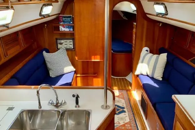Slide: The Image of Interior of 1995 Freedom 35 sailboat with blue seating and wooden finishes. - 8