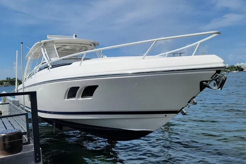 The Image of 2014 Intrepid 400 Cuddy boat docked on a sunny day, showcasing sleek design. - 0