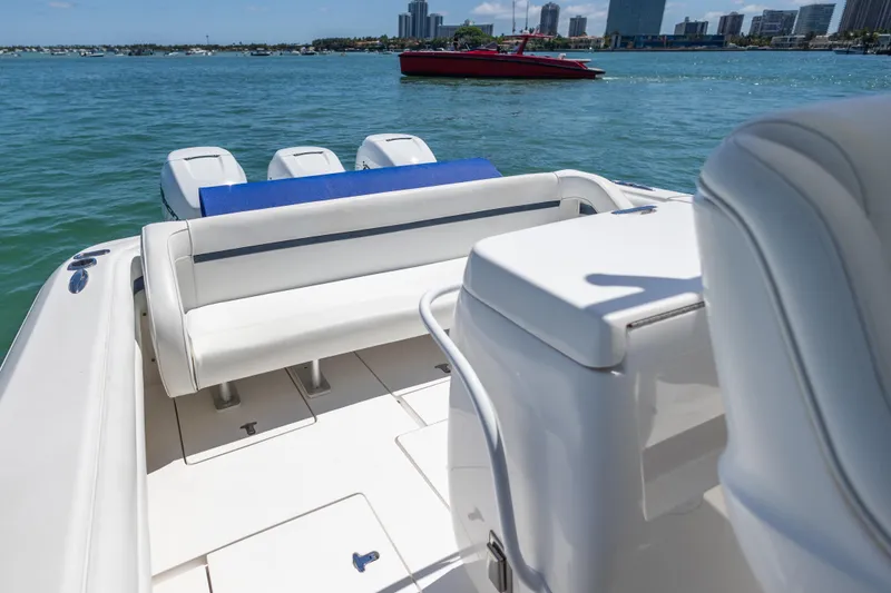 Slide: The Image of 2014 Intrepid 400 Cuddy boat interior with seating, ocean view, and city skyline. - 10