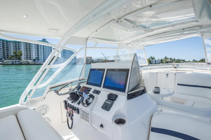 Slide: The Image of 2014 Intrepid 400 Cuddy boat interior with modern navigation system and waterfront view. - 16