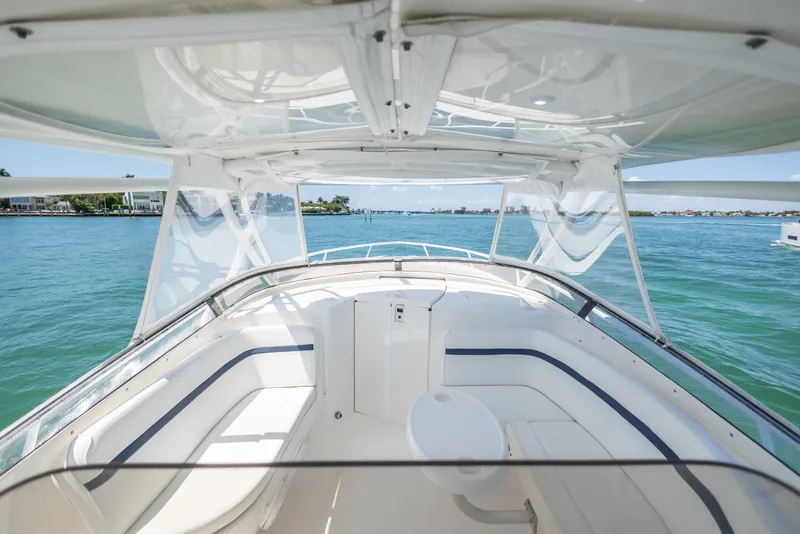 Slide: The Image of 2014 Intrepid 400 Cuddy boat interior with seating, overlooking calm blue waters. - 17