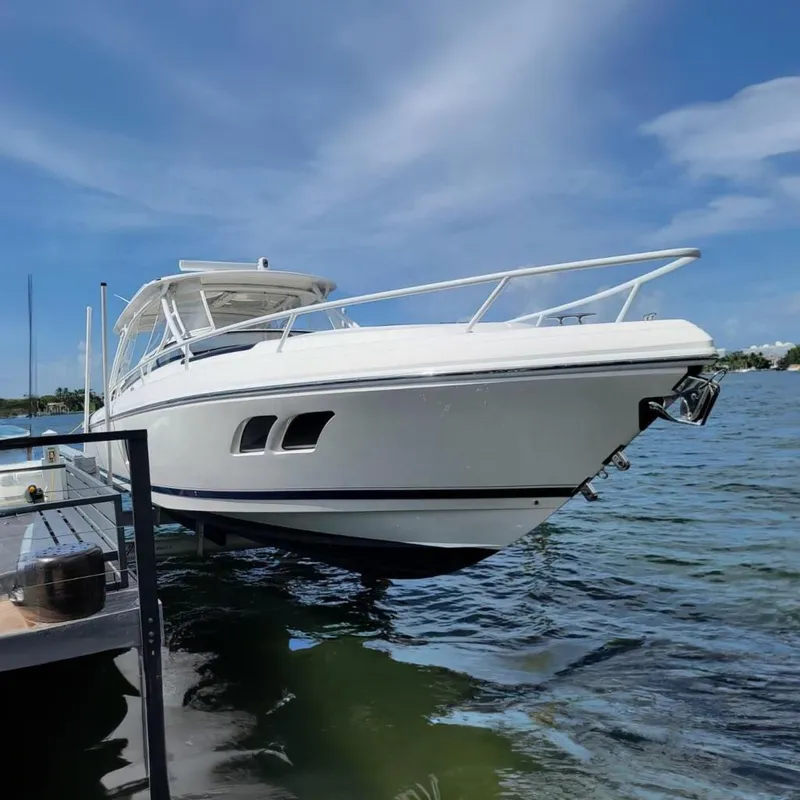 Slide: The Image of 2014 Intrepid 400 Cuddy boat docked on a sunny day, showcasing sleek design. - 5
