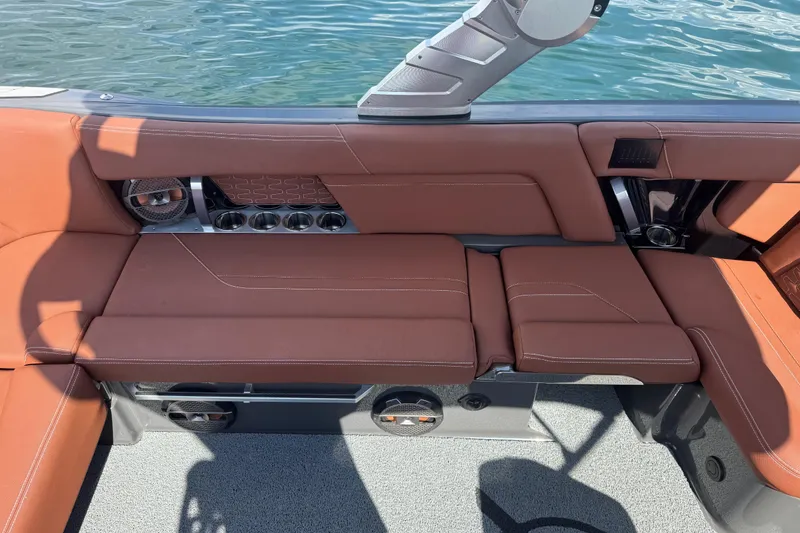 Slide: The Image of 2021 MasterCraft X24 boat interior with brown leather seating and cup holders. - 14