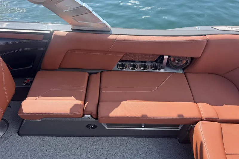 Slide: The Image of 2021 MasterCraft X24 boat interior with brown leather seating and cup holders. - 15