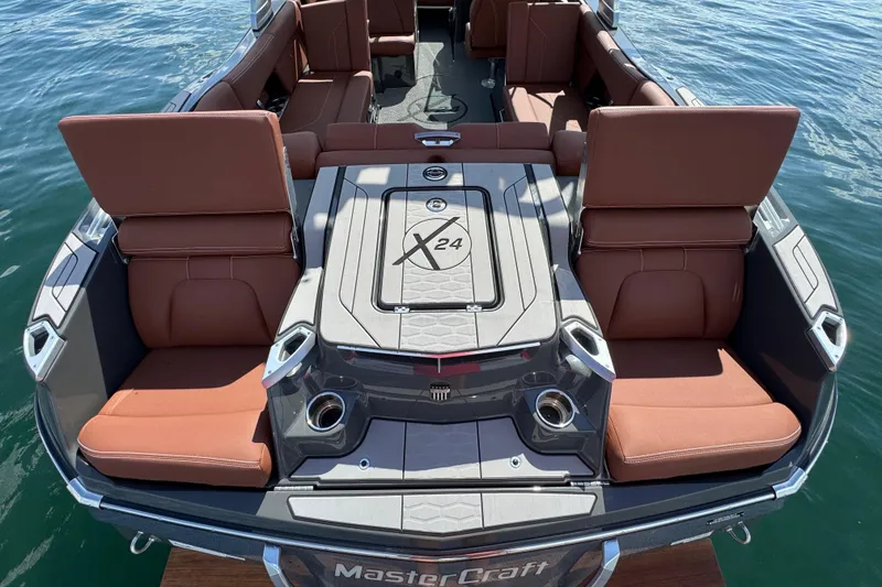 Slide: The Image of 2021 MasterCraft X24 boat interior with brown seating and sleek design on water. - 19