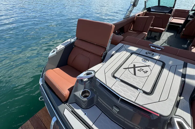 Slide: The Image of 2021 MasterCraft X24 boat with luxurious seating and sleek design on calm water. - 20