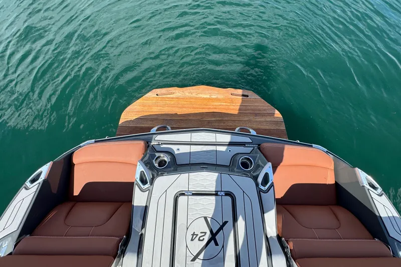 Slide: The Image of 2021 MasterCraft X24 boat interior with brown seats and swim platform on water. - 22