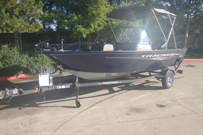 The Image of 2026 Tracker Pro Guide V-16 WT boat on trailer, parked outdoors. - 0