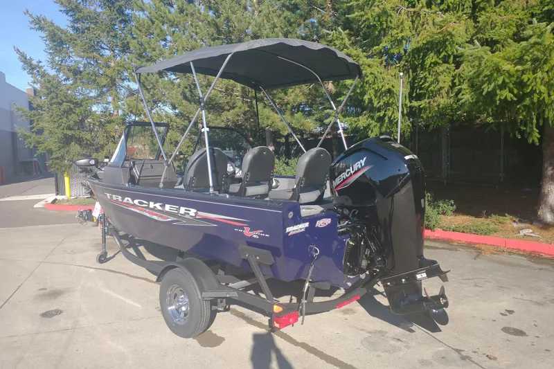 Slide: The Image of 2026 Tracker Pro Guide V-16 WT boat with Mercury engine, parked outdoors. - 2