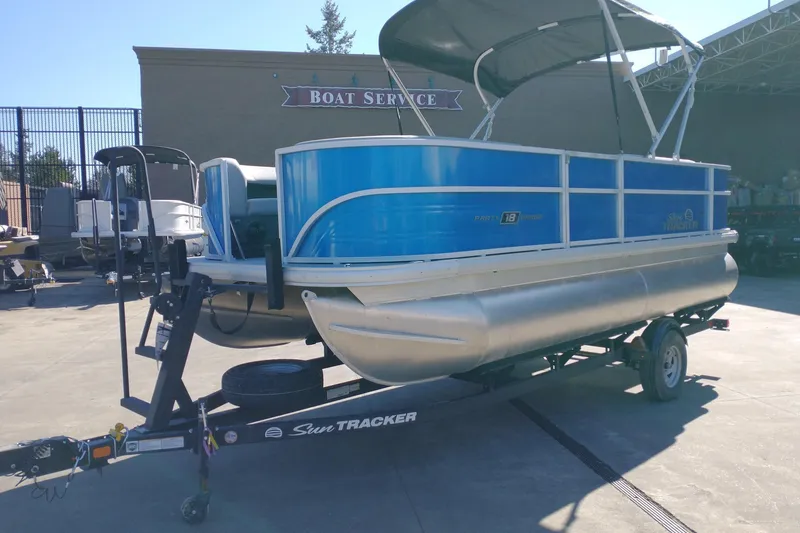 The Image of 2026 Sun Tracker Party Barge 18 DLX pontoon boat on trailer at boat service center. - 0