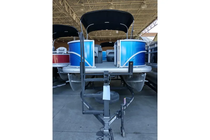 Slide: The Image of 2026 Sun Tracker Party Barge 18 DLX pontoon boat in showroom, front view. - 5
