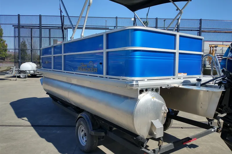 Slide: The Image of 2026 Sun Tracker Party Barge 18 DLX pontoon boat on trailer, blue exterior. - 7