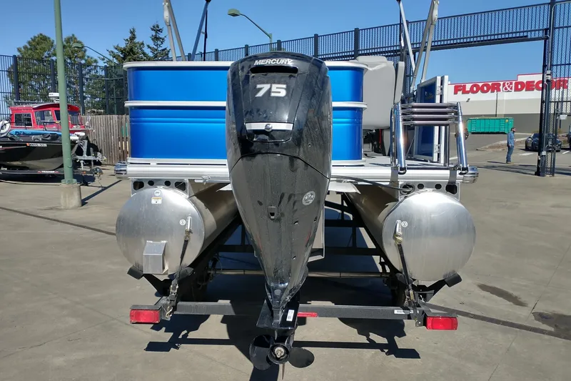 Slide: The Image of 2026 Sun Tracker Party Barge 18 DLX pontoon boat with Mercury 75 engine, parked outdoors. - 8