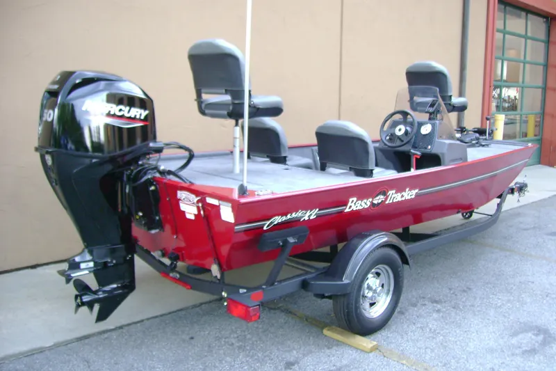 Slide: The Image of 2026 Tracker Bass Tracker Classic XL boat with Mercury engine, parked on trailer. - 2