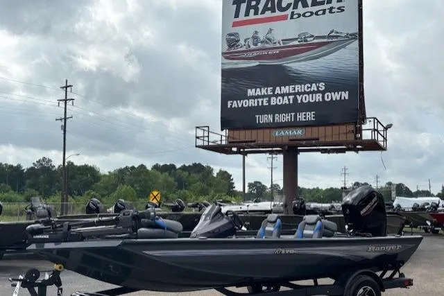 The Image of 2026 Ranger RT178C boat displayed outdoors near a Tracker Boats billboard. - 0