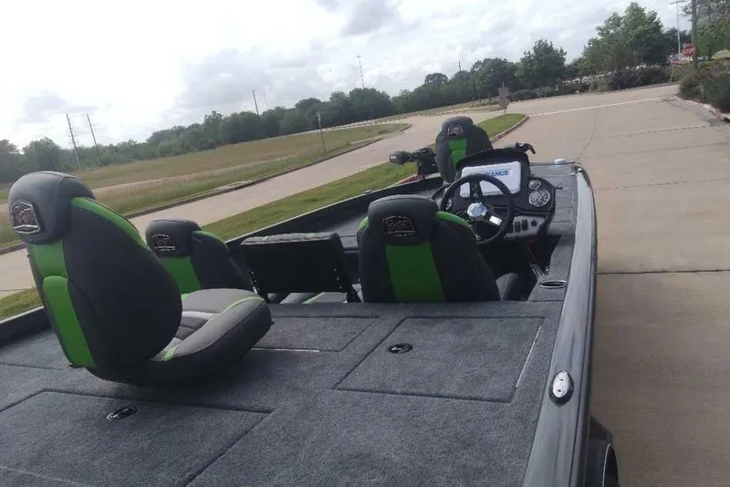 Slide: The Image of 2026 Ranger RT198P boat with green-accented seats on a paved road. - 18