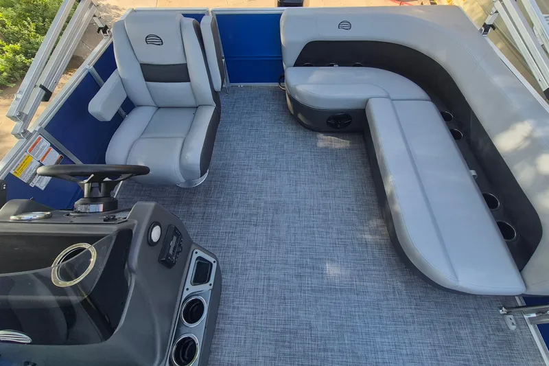 Slide: The Image of 2026 Sun Tracker Party Barge 16 DLX interior with gray seating and steering console. - 12