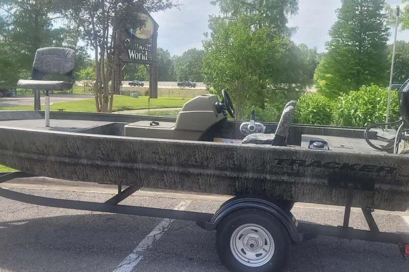 The Image of 2026 Tracker Grizzly 1754 SC boat on trailer, parked outdoors, surrounded by greenery. - 0