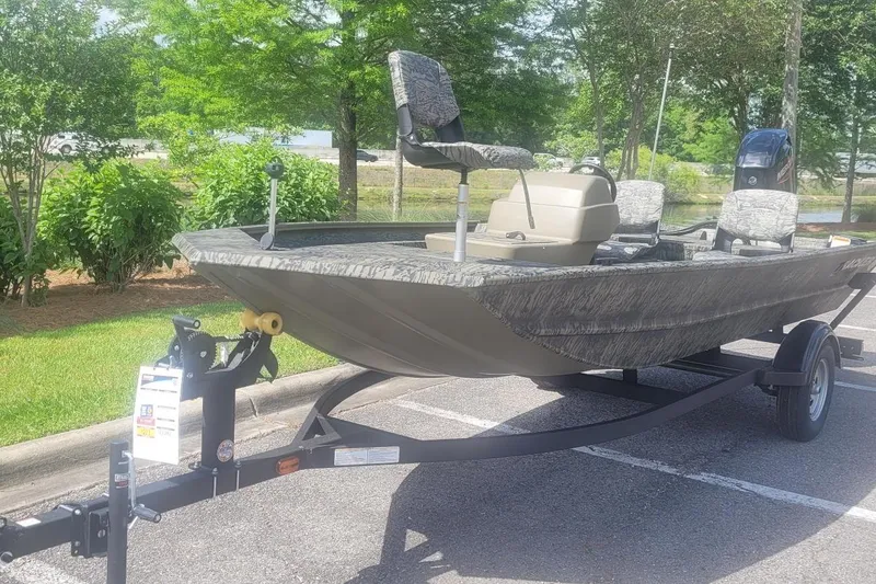 Slide: The Image of 2026 Tracker Grizzly 1754 SC boat on trailer in parking lot, surrounded by greenery. - 4