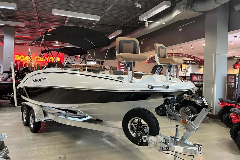 Slide: The Image of 2026 Tahoe 2150 boat displayed indoors on a trailer at a showroom. - 1