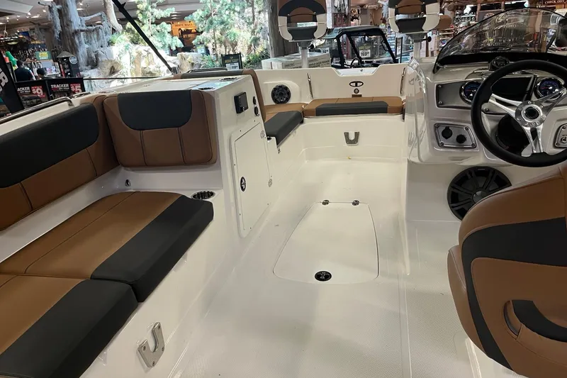 Slide: The Image of 2026 Tahoe 2150 boat interior with brown and black seating, modern steering, and spacious layout. - 6