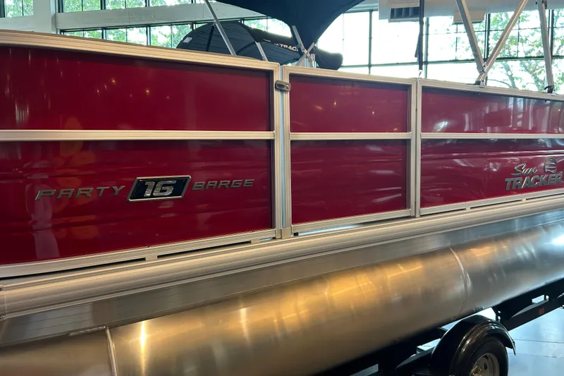 Slide: The Image of 2026 Sun Tracker Party Barge 16 DLX pontoon boat with red panels and silver trim. - 2