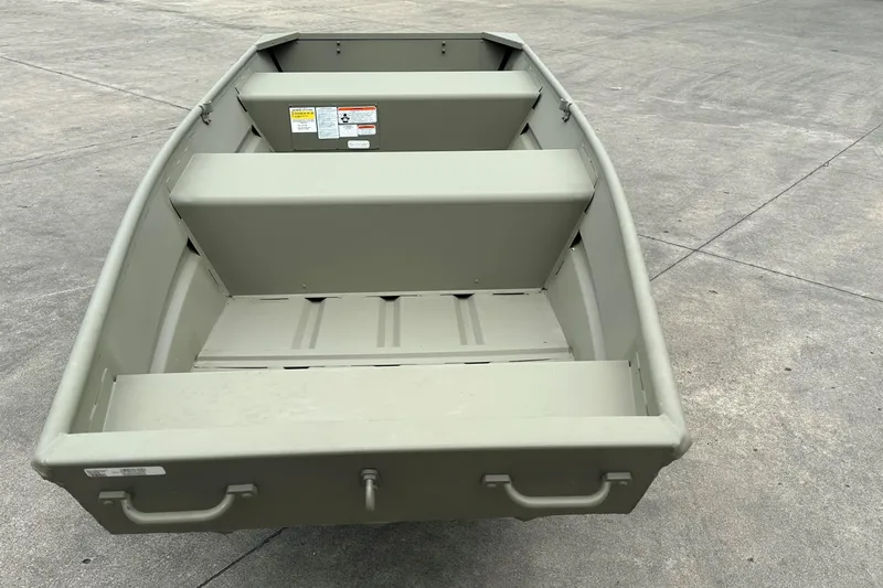 Slide: The Image of 2026 Tracker Grizzly 12 Jon boat on concrete surface, showcasing interior seating and handles. - 4