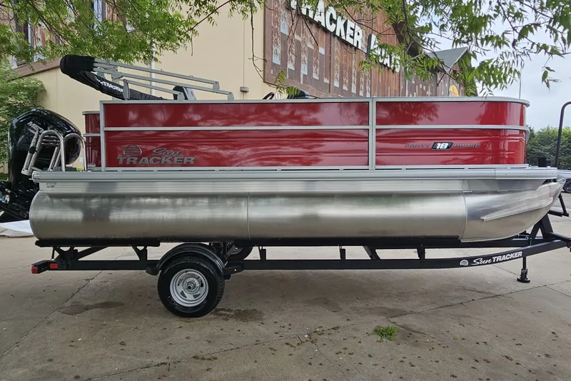 Slide: The Image of 2026 Sun Tracker Party Barge 18 DLX pontoon boat on trailer, parked outdoors. - 3