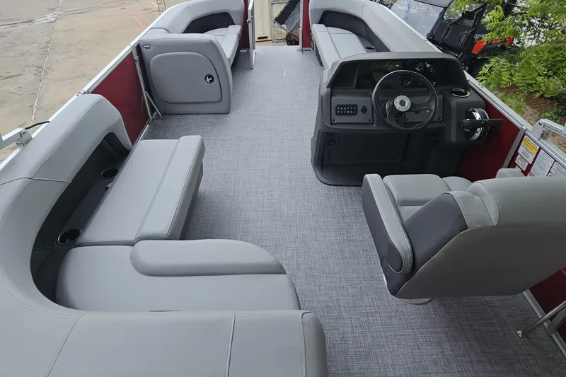 Slide: The Image of 2026 Sun Tracker Party Barge 18 DLX interior with gray seating and steering console. - 7