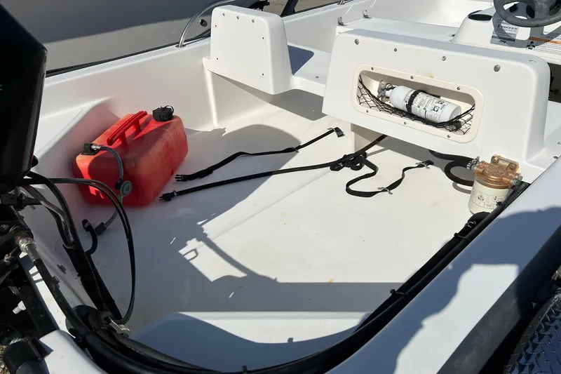 Slide: The Image of 2006 Boston Whaler 150 Sport interior with fuel tank and safety equipment. - 10