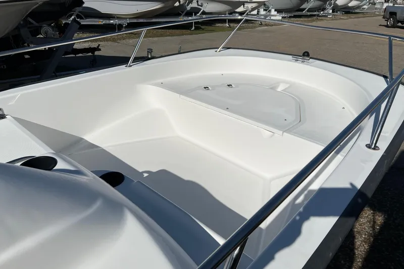 Slide: The Image of 2006 Boston Whaler 150 Sport boat interior, showcasing sleek white design and spacious seating. - 8