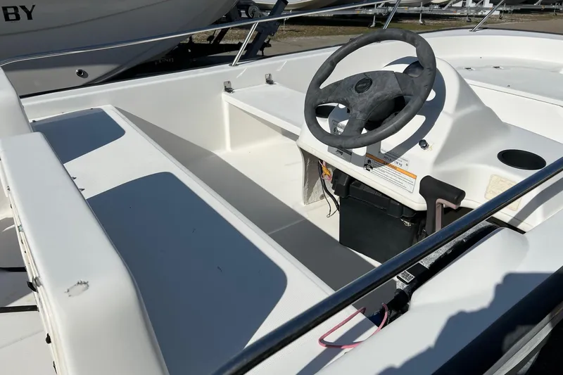 Slide: The Image of 2006 Boston Whaler 150 Sport boat interior with steering wheel and seating. - 9