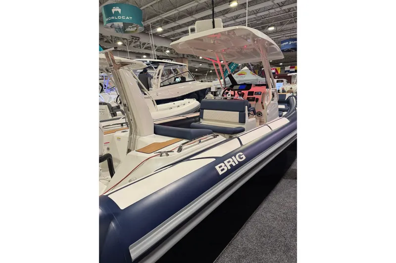 Slide: The Image of 2026 Brig Eagle 8 boat displayed at an indoor boat show, featuring sleek design and modern amenities. - 2