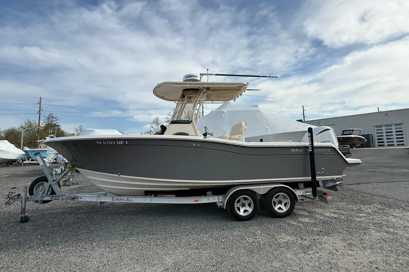 The Image of 2021 Grady-White Fisherman 236 boat on trailer, parked outdoors under cloudy sky. - 0