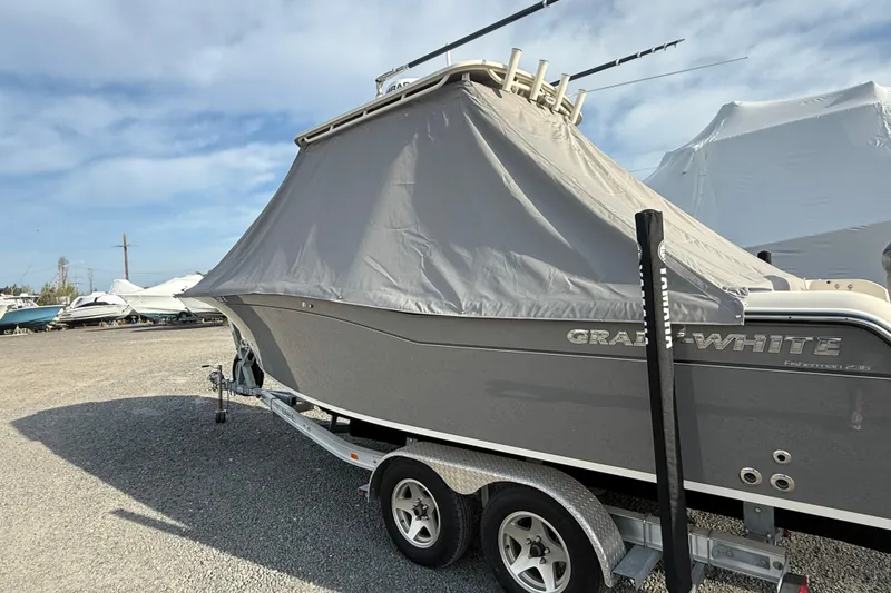 Slide: The Image of 2021 Grady-White Fisherman 236 boat covered on a trailer in a storage yard. - 4