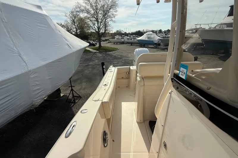 Slide: The Image of 2021 Grady-White Fisherman 236 boat in marina, surrounded by covered vessels. - 9