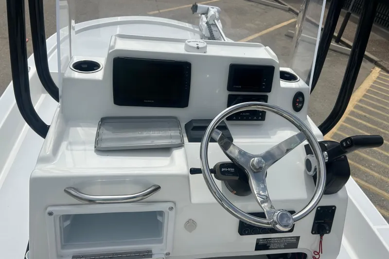 Slide: The Image of 2023 Shallow Sport 18 Sport boat dashboard with steering wheel and navigation controls. - 12