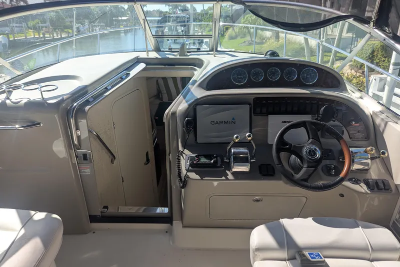 Slide: The Image of 2005 Sea Ray 290 Amberjack helm with Garmin navigation, steering wheel, and cabin entrance. - 11