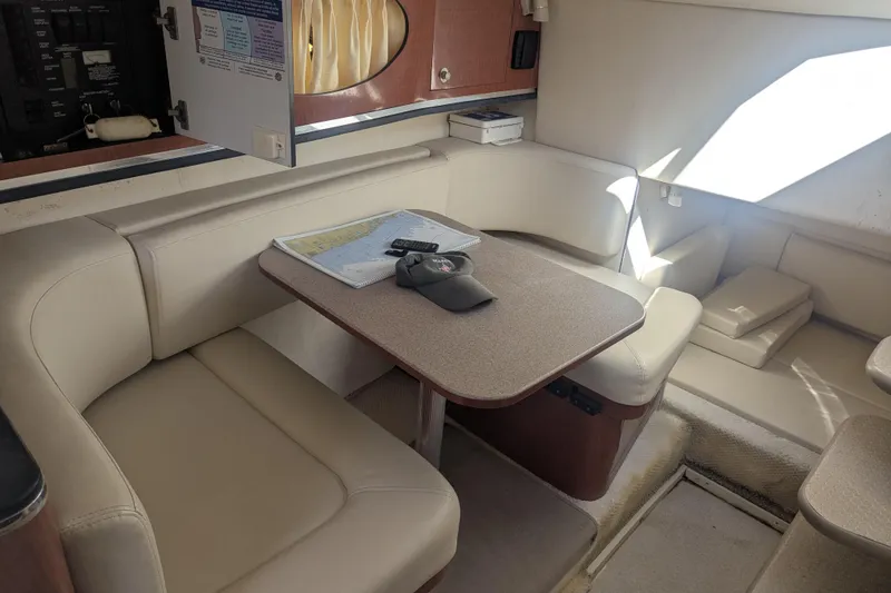 Slide: The Image of 2005 Sea Ray 290 Amberjack cabin interior with seating, table, and navigation map. - 15