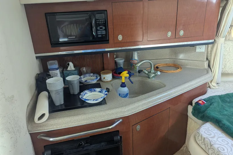 Slide: The Image of 2005 Sea Ray 290 Amberjack kitchenette with microwave, sink, and countertop essentials. - 18