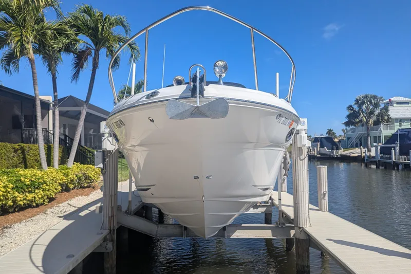 Slide: The Image of 2005 Sea Ray 290 Amberjack boat docked, surrounded by palm trees and waterfront homes. - 2