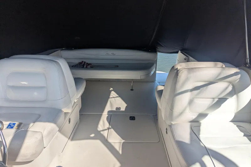 Slide: The Image of Interior of 2005 Sea Ray 290 Amberjack boat with white seating and shaded canopy. - 21
