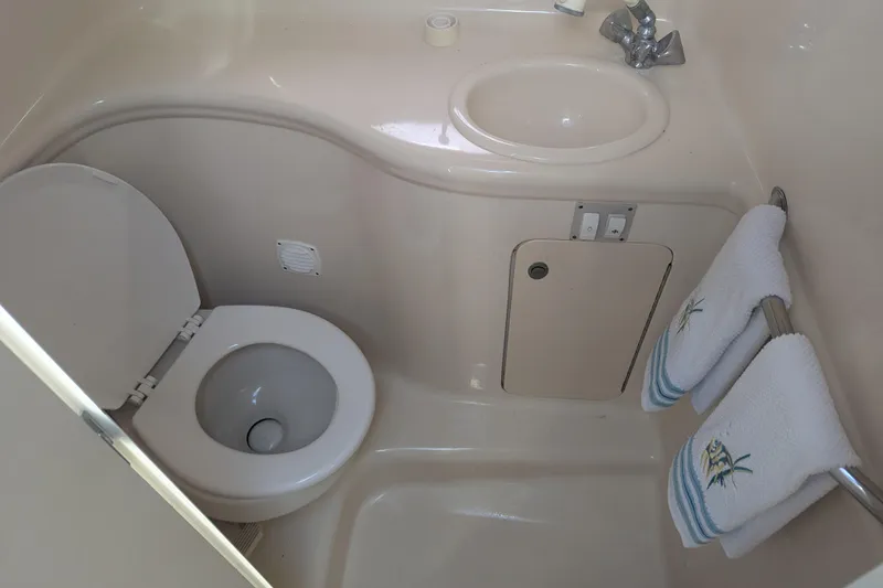 Slide: The Image of Compact bathroom in 2005 Sea Ray 290 Amberjack boat with toilet, sink, and towels. - 22