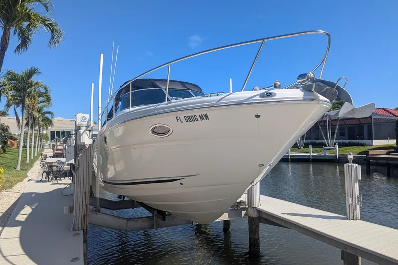 Slide: The Image of 2005 Sea Ray 290 Amberjack boat docked, surrounded by palm trees and clear blue sky. - 3