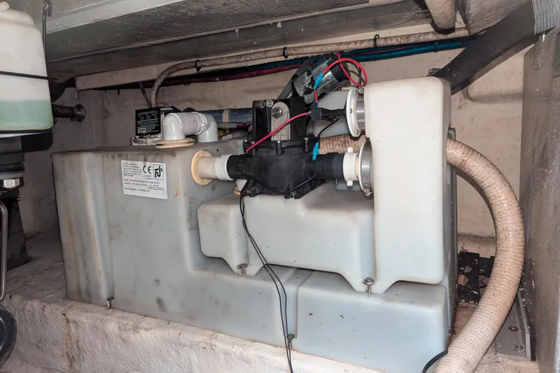 Slide: The Image of 2005 Sea Ray 290 Amberjack engine compartment with water tank and plumbing components. - 43