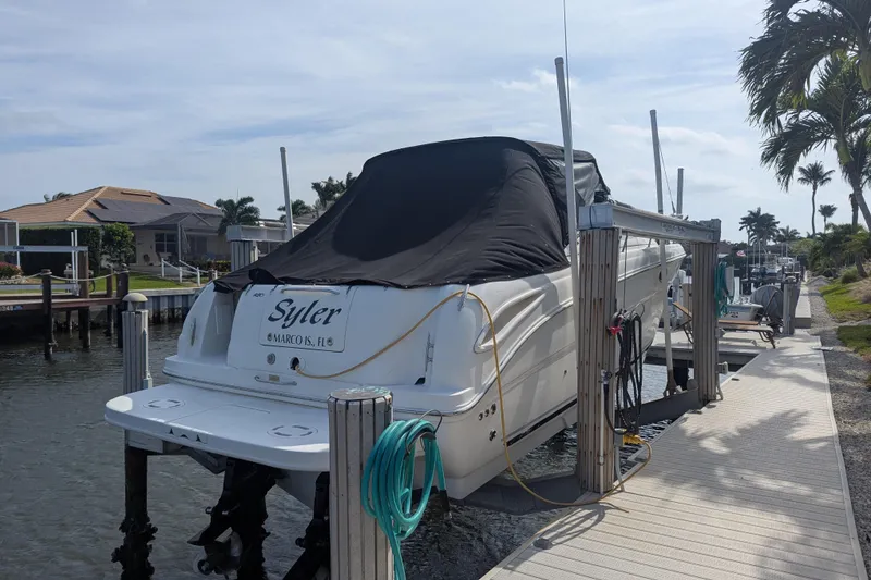 Slide: The Image of 2005 Sea Ray 290 Amberjack boat docked, covered, in a sunny waterfront setting. - 5