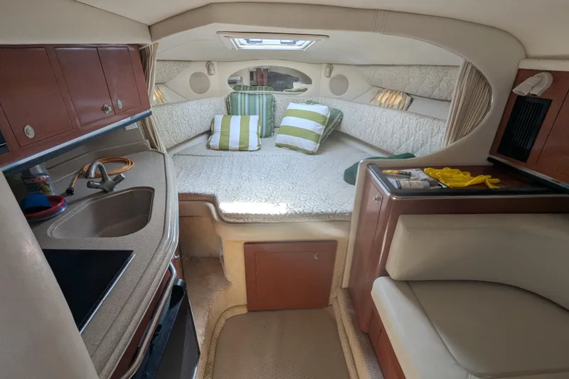 Slide: The Image of 2005 Sea Ray 290 Amberjack cabin interior with bed, kitchenette, and seating area. - 50